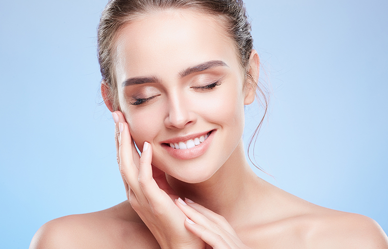 Smiling woman with smooth, glowing skin highlighting Bellafill’s effectiveness for treating wrinkles and smile lines.