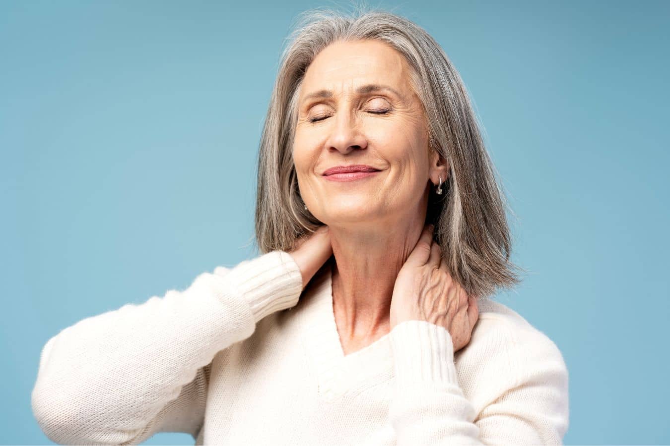 Woman gently holding neck with eyes closed, representing neck lift recovery and improved jawline contour